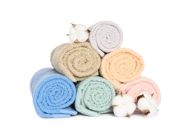 Photo of Clean soft towels with cotton flowers isolated on white