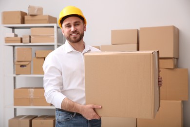 Young man with cardboard box at warehouse