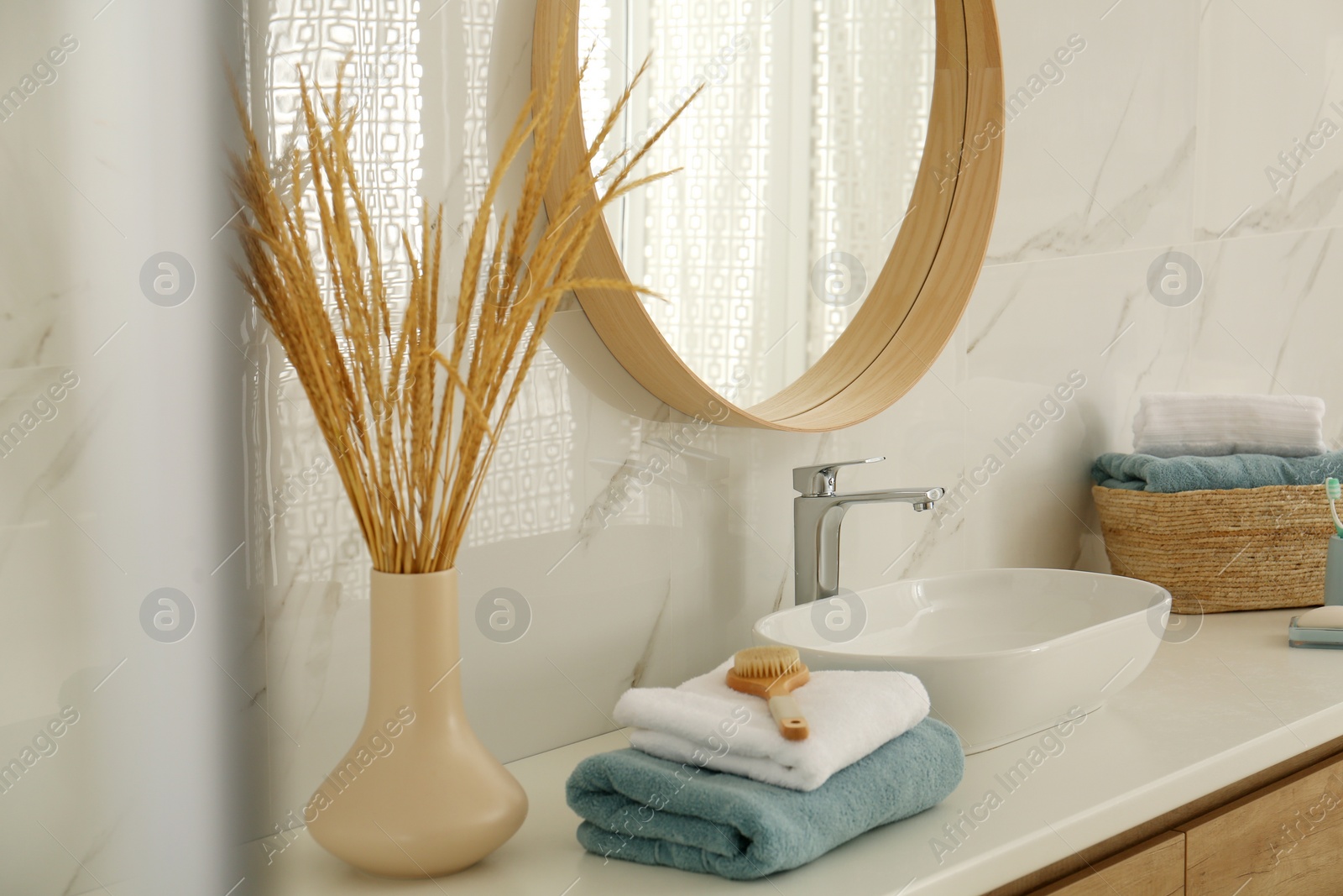 Photo of Round mirror over vessel sink in stylish bathroom