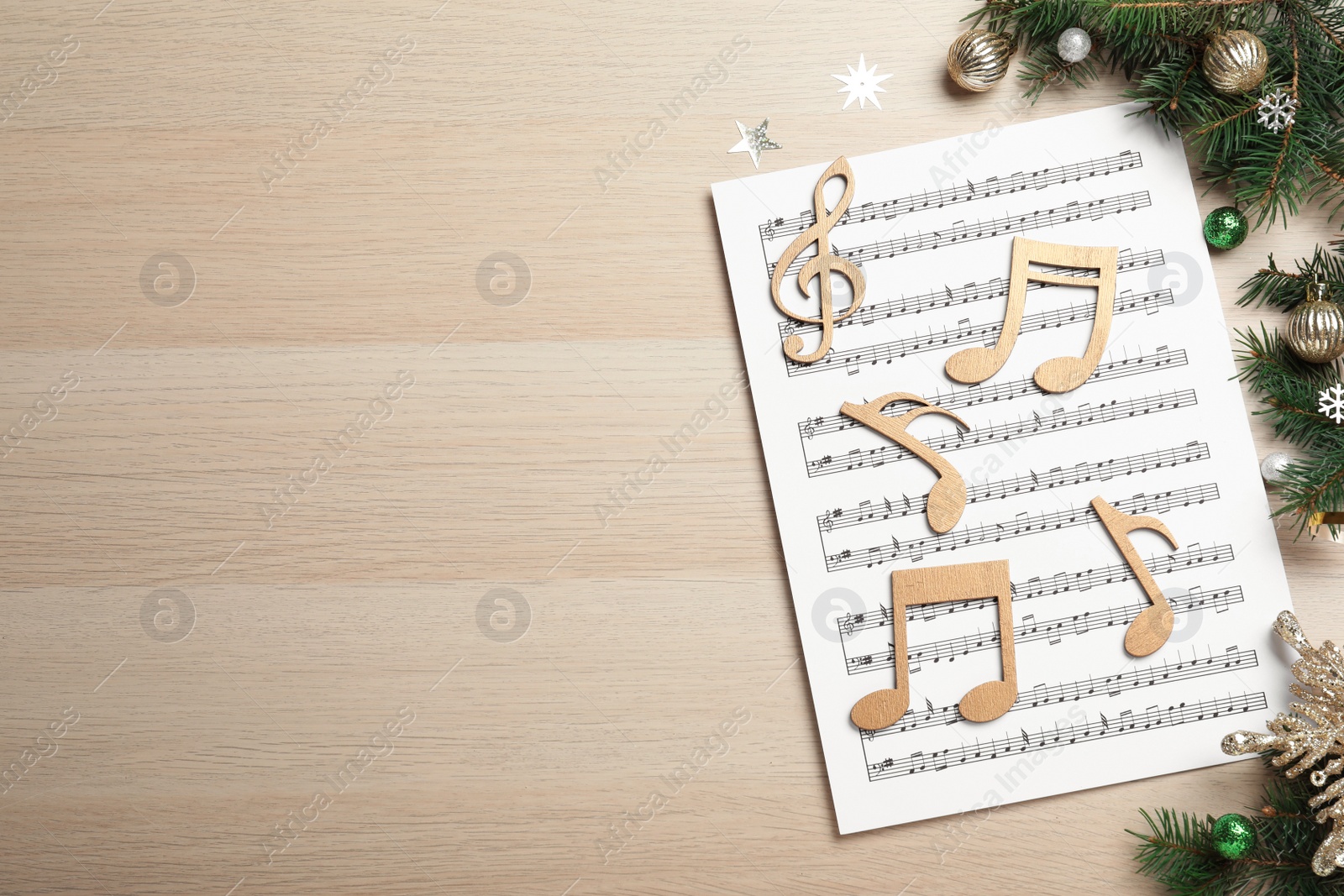 Photo of Flat lay composition with Christmas music sheets on wooden background. Space for text