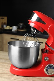 Photo of Modern stand mixer on wooden table in kitchen, closeup. Home appliance