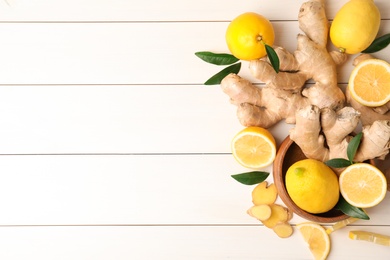 Photo of Fresh lemons and ginger on white wooden table, flat lay. Space for text