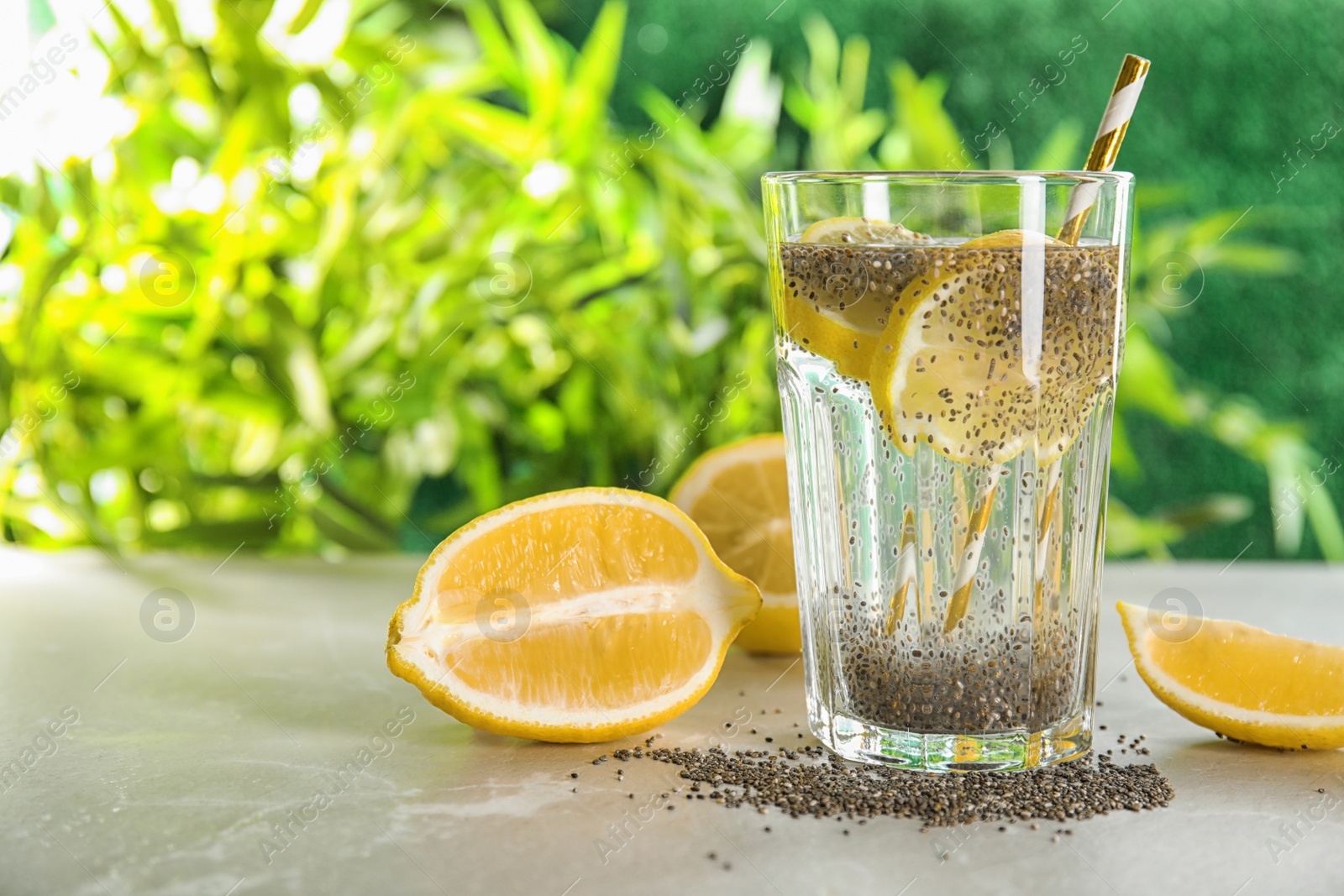 Photo of Glass of water with chia seeds and lemon on table. Space for text