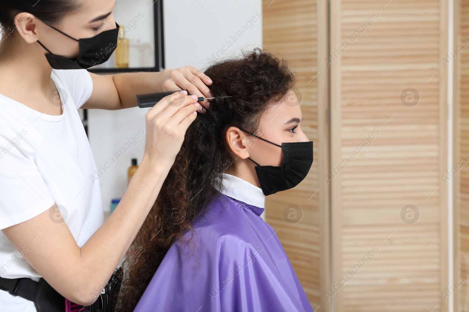 Photo of Professional stylist working with client in salon. Hairdressing services during Coronavirus quarantine