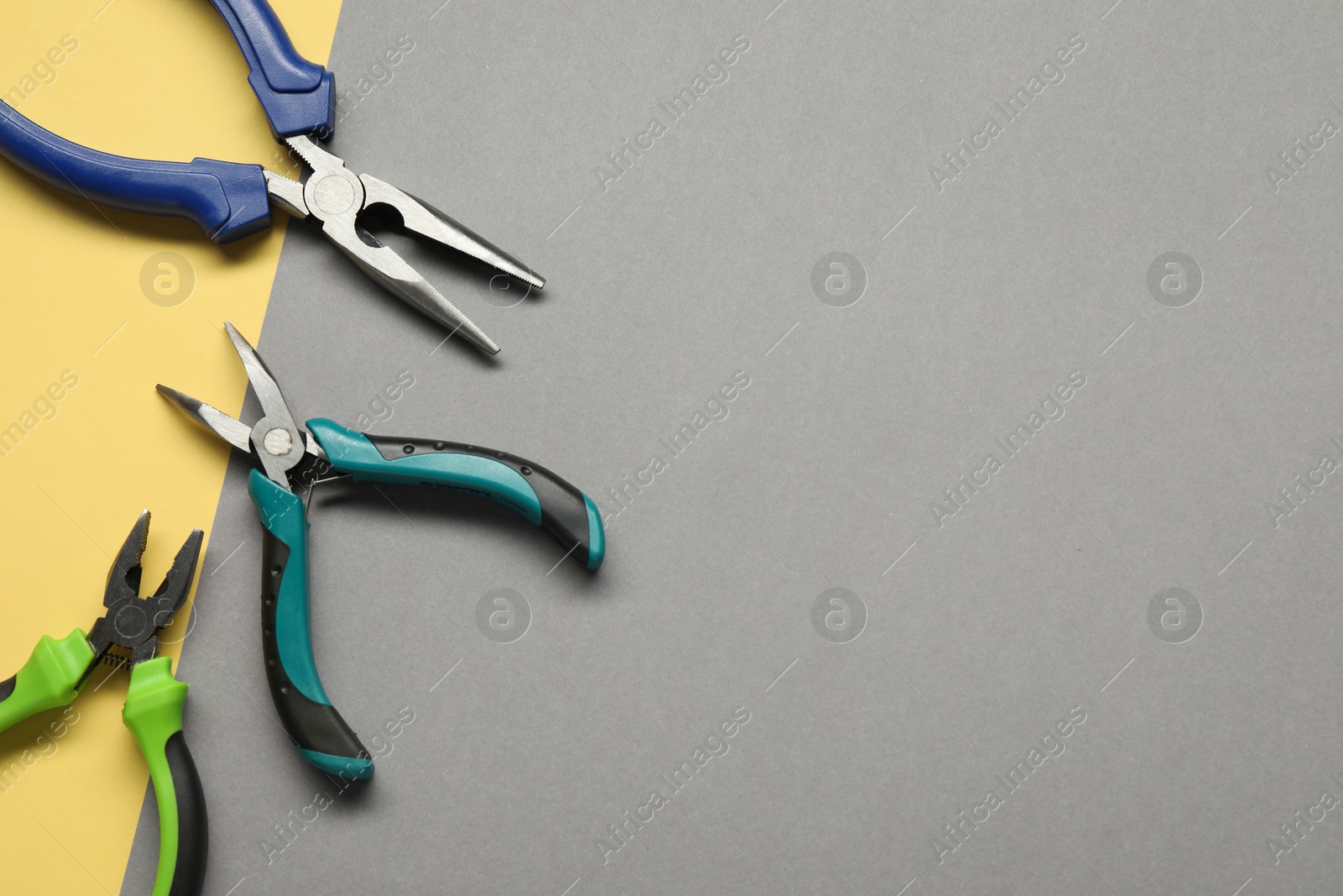 Photo of Different pliers on color background, flat lay. Space for text