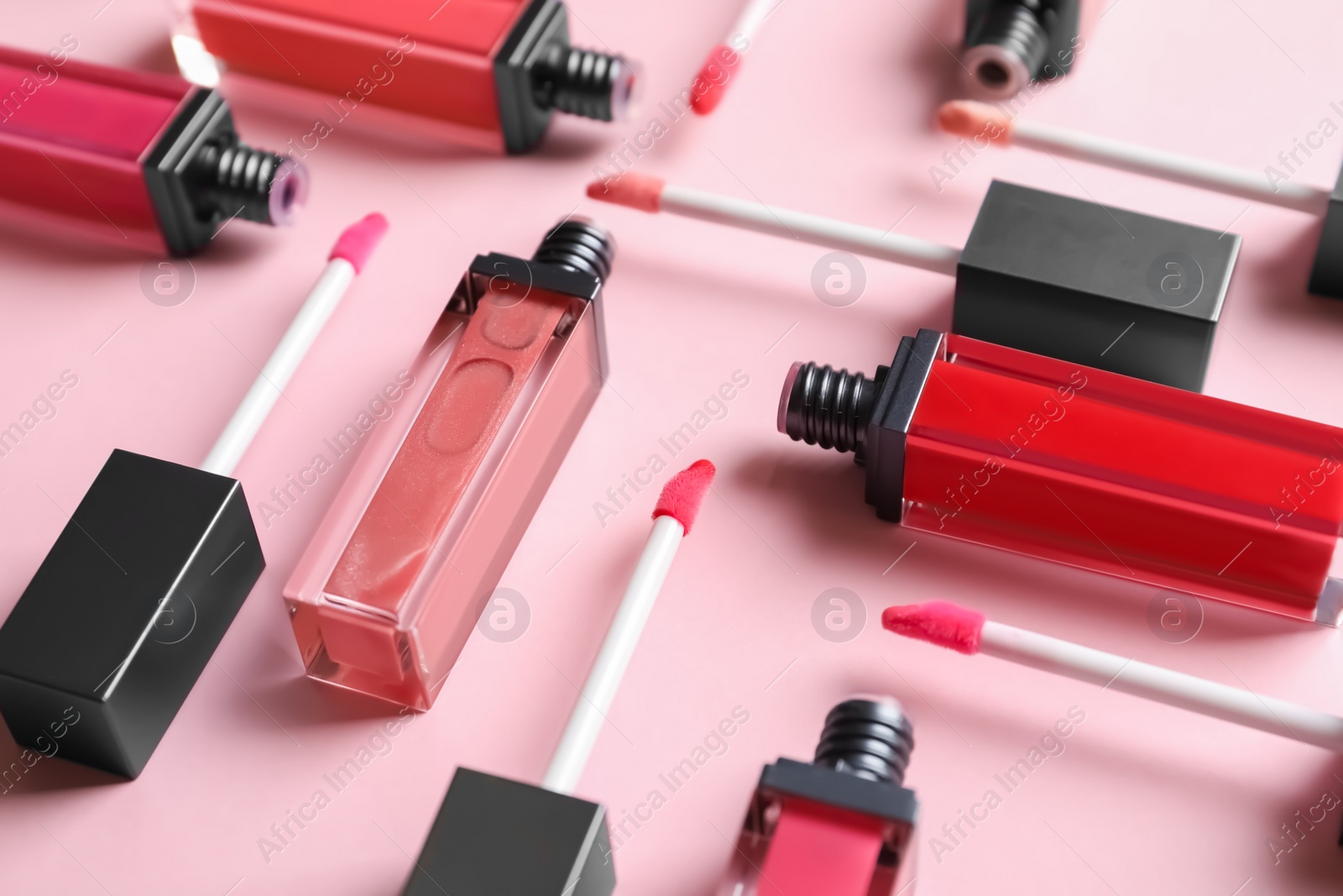 Photo of Composition of liquid lipsticks on color background