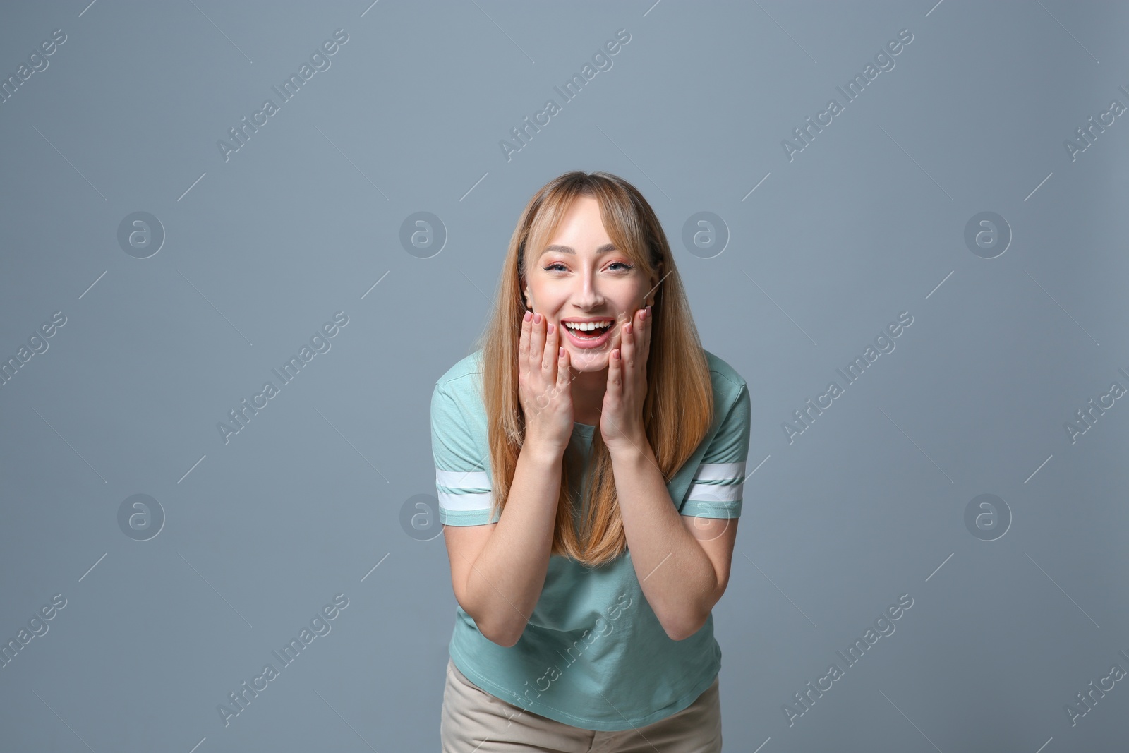 Photo of Beautiful young woman laughing on grey background. Funny joke