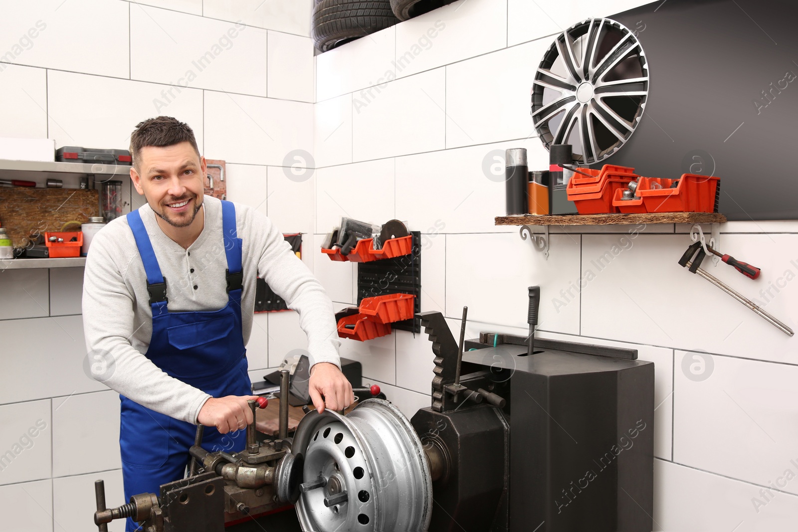 Photo of Mechanic working with car disk lathe machine at tire service