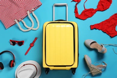 Flat lay composition with suitcase and accessories on color background. Summer vacation