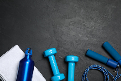Photo of Gym equipment on black background, flat lay. Space for text