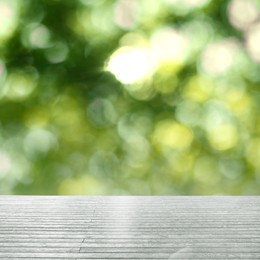 Image of Empty wooden surface against blurred green background. Bokeh effect