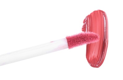 Stroke of pink lip gloss and applicator isolated on white, top view