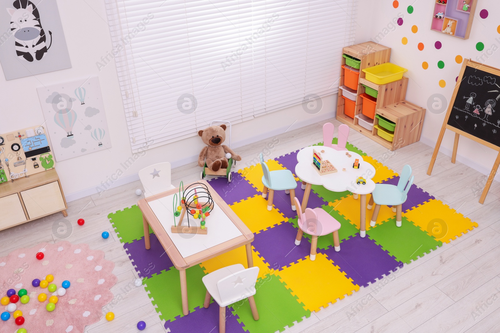 Photo of Stylish kindergarten interior with toys and modern furniture, above view