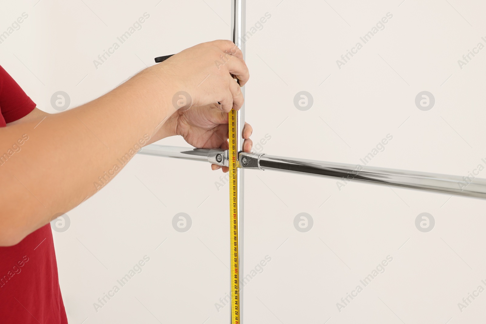 Photo of Worker measuring metal pipes for installation, closeup