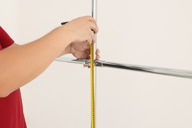 Photo of Worker measuring metal pipes for installation, closeup