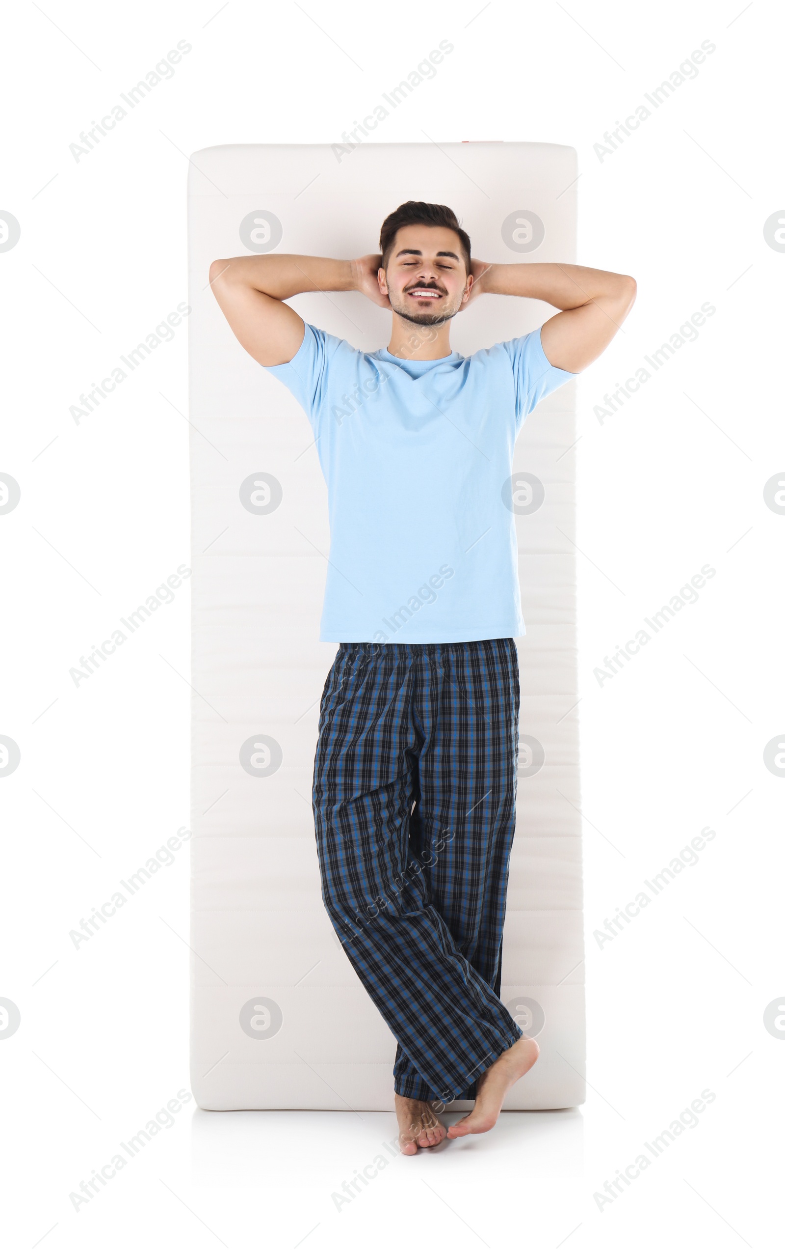 Photo of Young man with comfortable mattress isolated on white