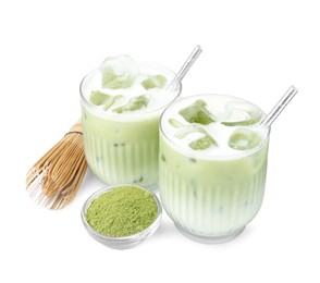Glasses of tasty iced matcha latte, bamboo whisk and powder isolated on white