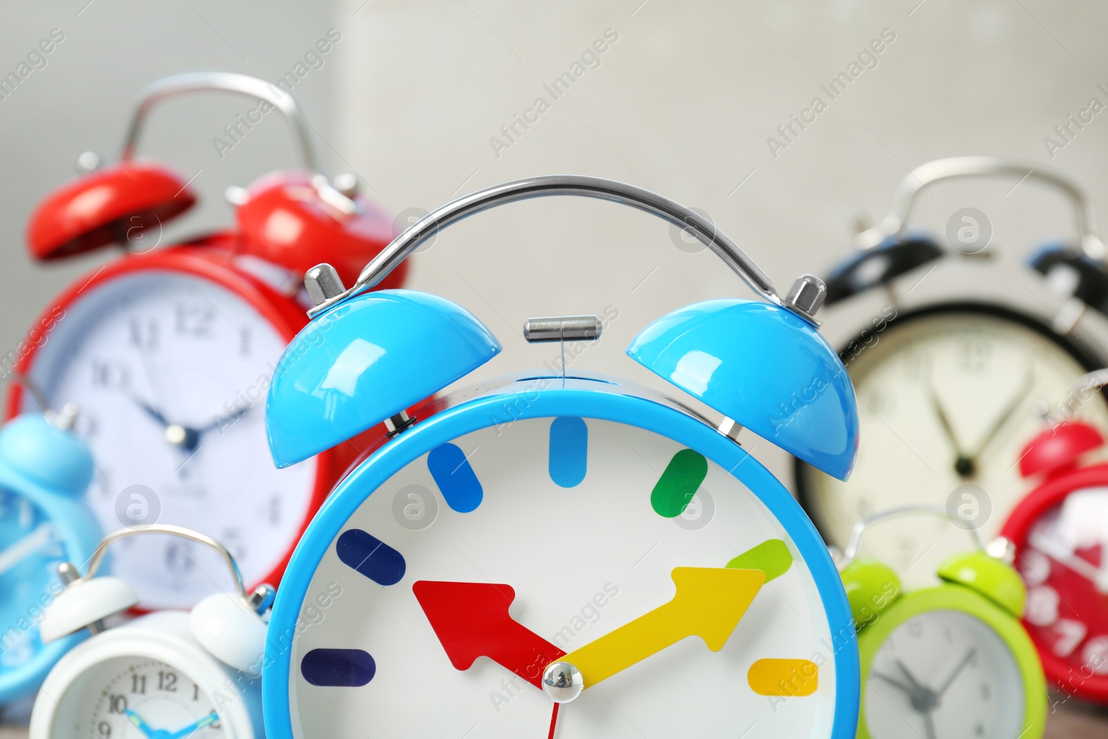 Photo of Blue alarm clock and many others on background. Time change concept