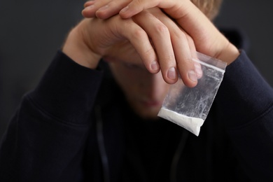 Photo of Criminal holding plastic bag with drug, closeup