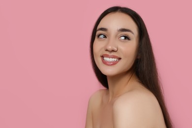 Photo of Portrait of beautiful young woman with elegant makeup on pink background. Space for text