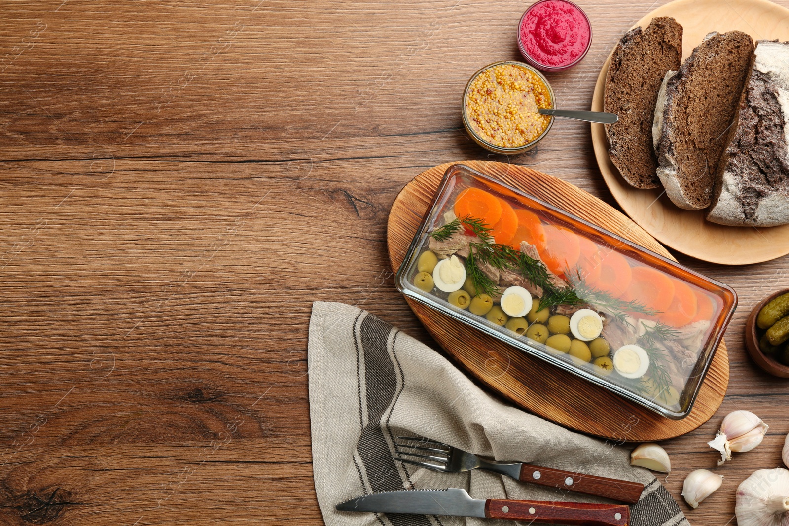 Photo of Delicious aspic with meat served on wooden table, flat lay. Space for text