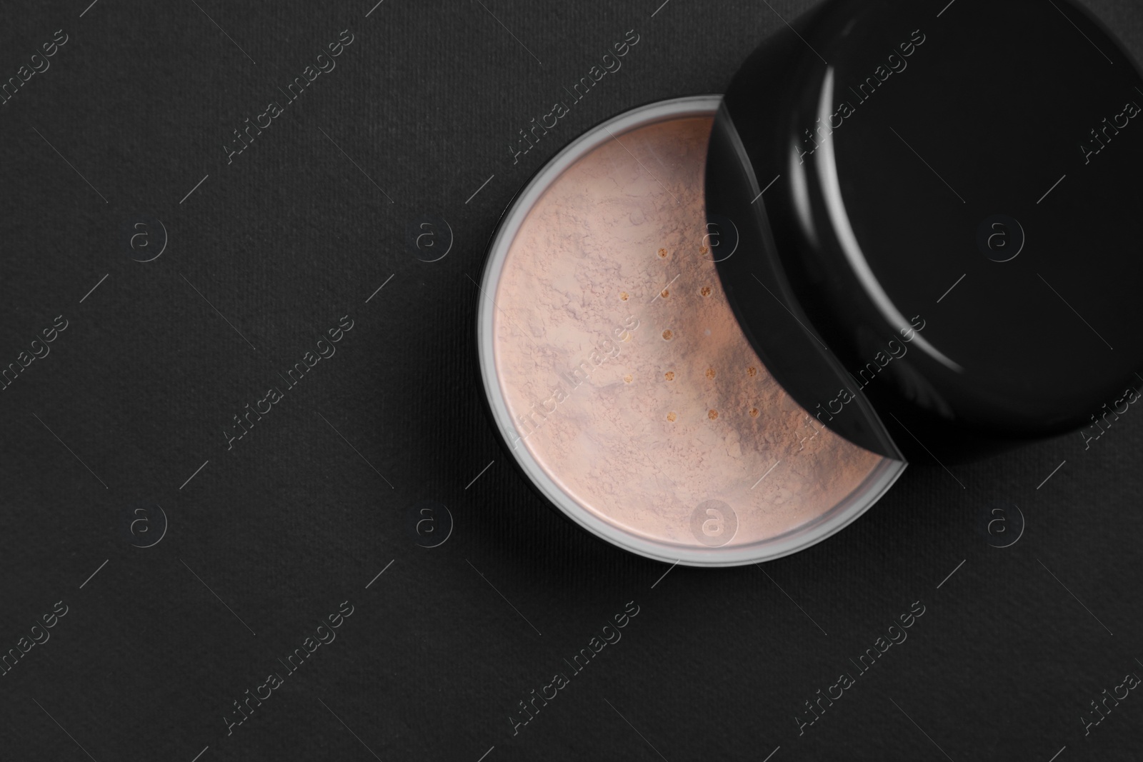 Photo of One open face powder on black background, top view. Space for text