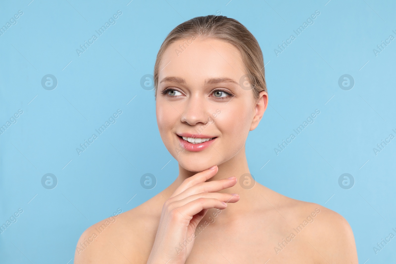 Photo of Portrait of young woman with beautiful face on blue background