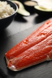 Fresh salmon for sushi on dark table, closeup