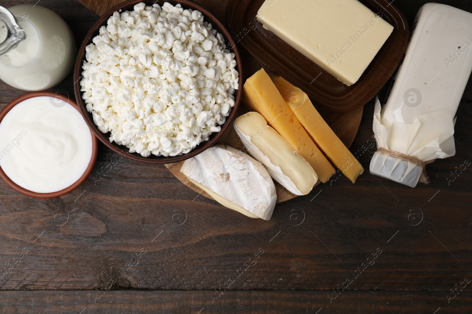 Photo of Different fresh dairy products on wooden table, flat lay. Space for text