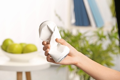 Photo of Woman holding crumpled aluminum can on blurred background. Metal waste recycling