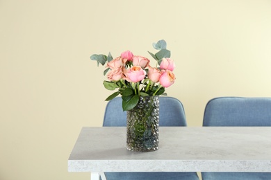 Photo of Vase with beautiful flowers as element of interior design on table in room. Space for text