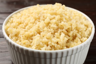 Delicious bulgur in bowl on table, closeup