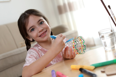 Photo of Little girl painting glass at table indoors. Creative hobby