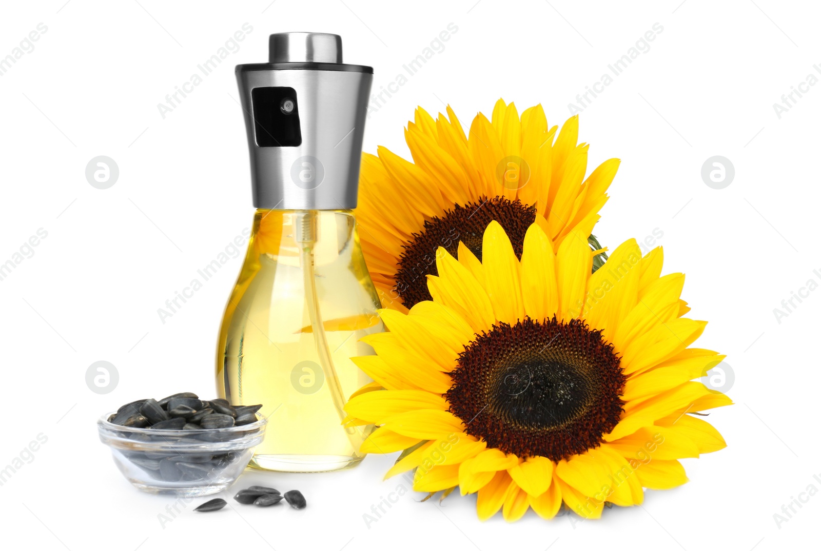 Photo of Spray bottle with cooking oil, sunflowers and seeds on white background