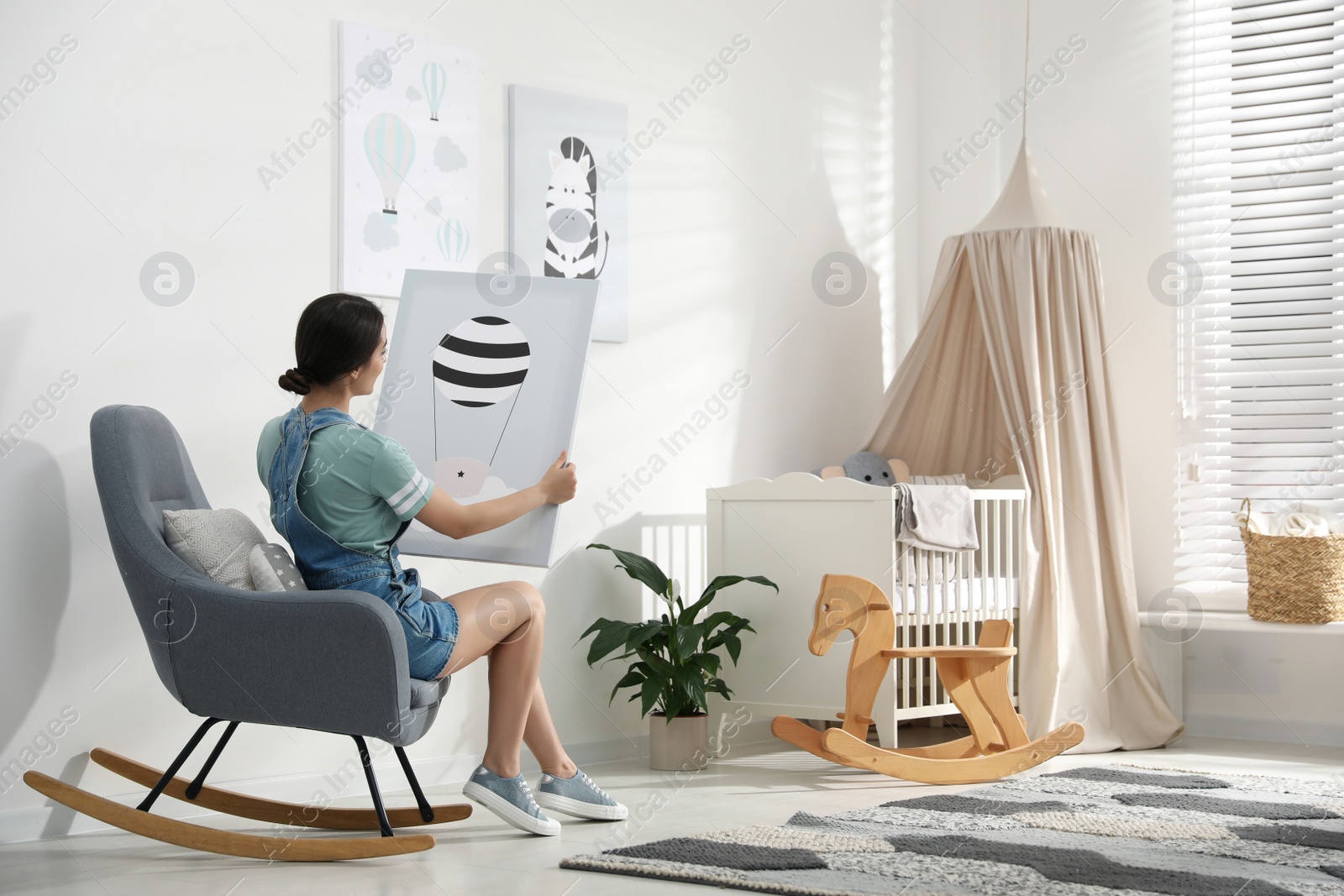 Photo of Decorator with picture sitting indoors. Children's room interior design