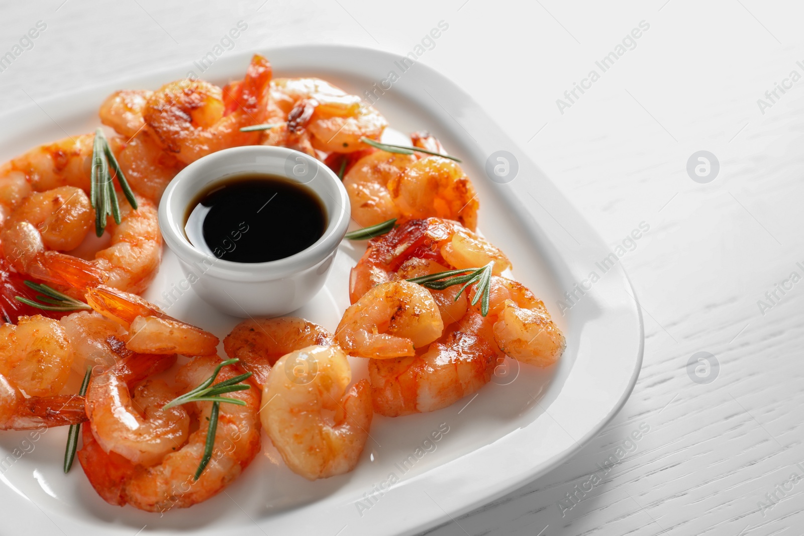 Photo of Plate with delicious fried shrimps and sauce on table