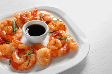 Photo of Plate with delicious fried shrimps and sauce on table