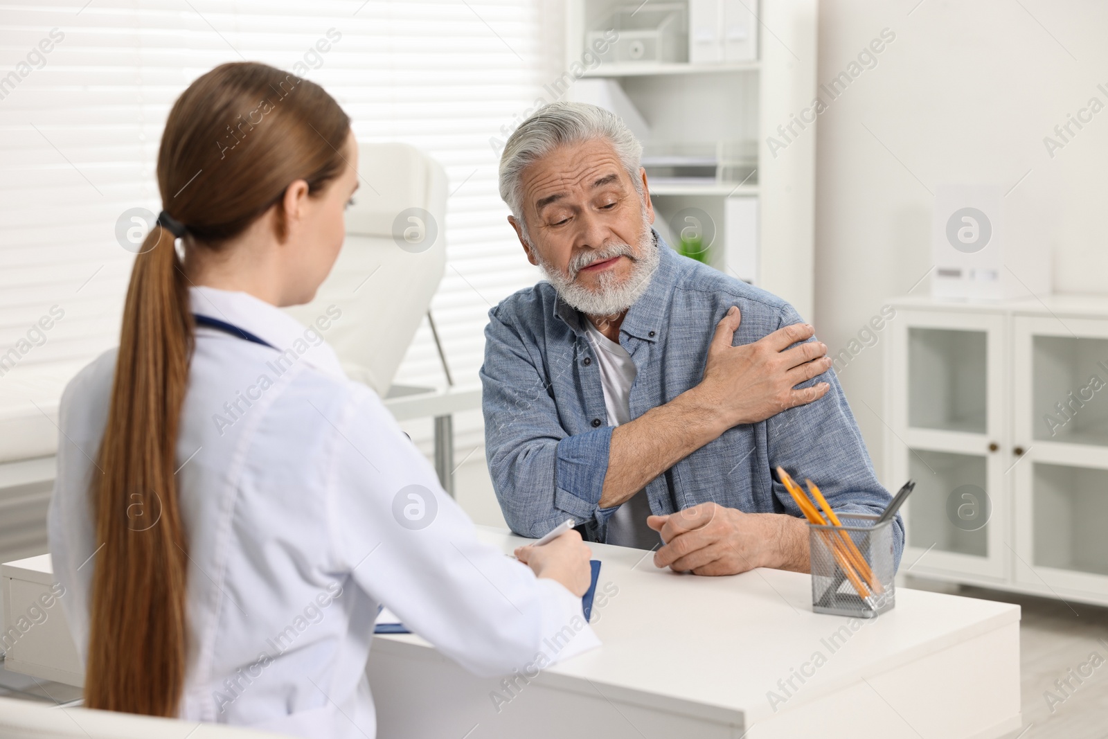 Photo of Arthritis symptoms. Doctor consulting patient with shoulder pain in hospital