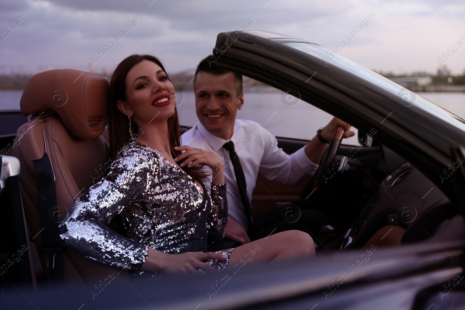 Photo of Beautiful couple in luxury convertible car outdoors