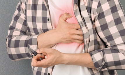 Young man having heart attack, closeup