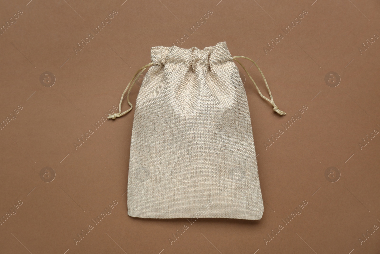 Photo of Burlap bag on brown background, top view