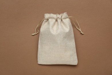 Photo of Burlap bag on brown background, top view