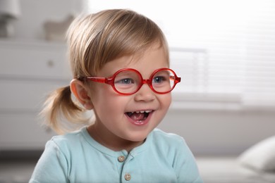 Photo of Cute little girl in glasses at home