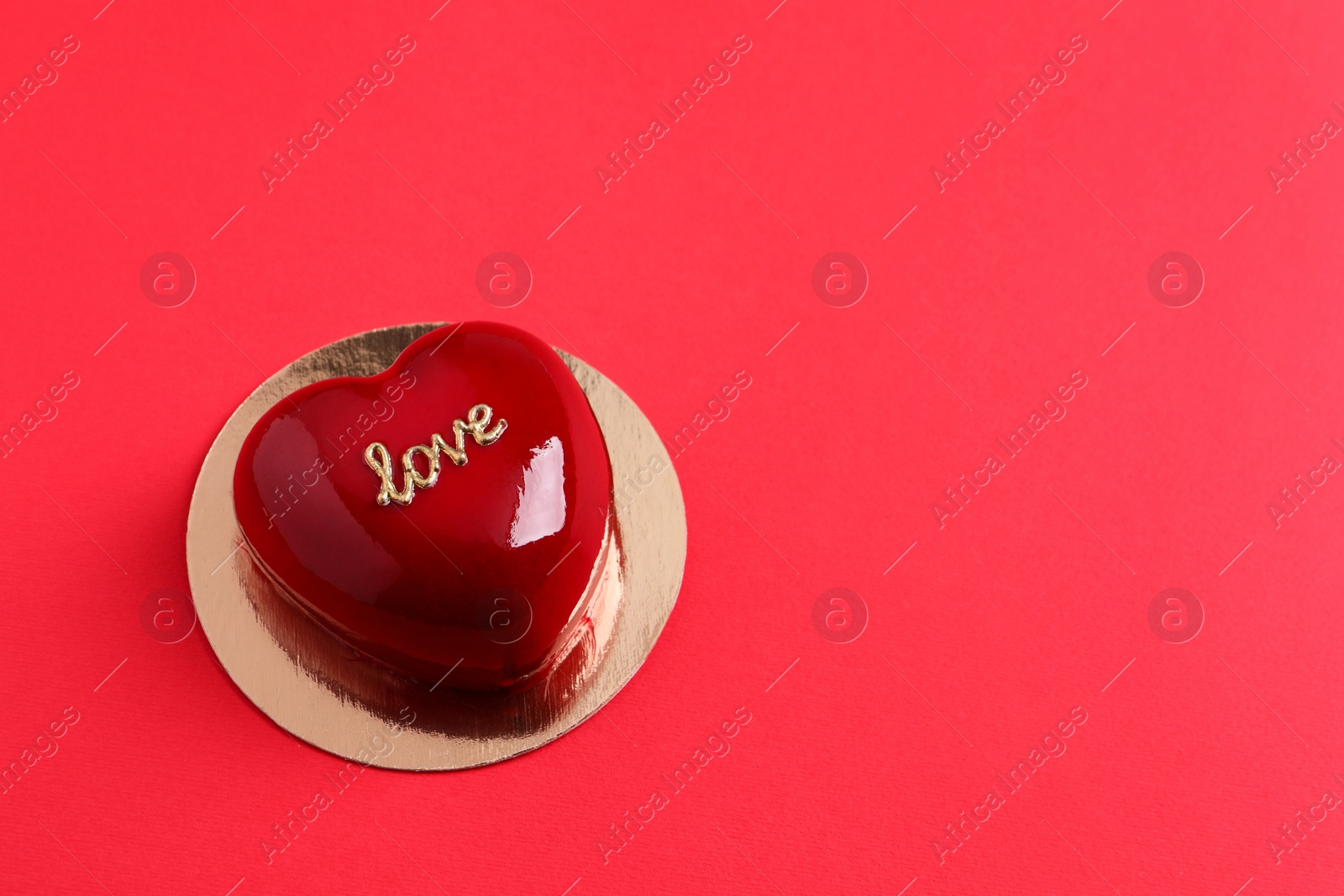 Photo of St. Valentine's Day. Delicious heart shaped cake on red background, above view. Space for text