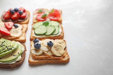 Tasty toast bread with fruits, berries and vegetables on light background, closeup