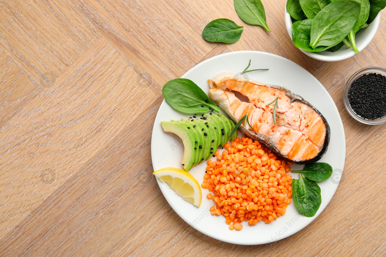 Photo of Plate with healthy food high in vegetable fats on wooden table, flat lay. Space for text