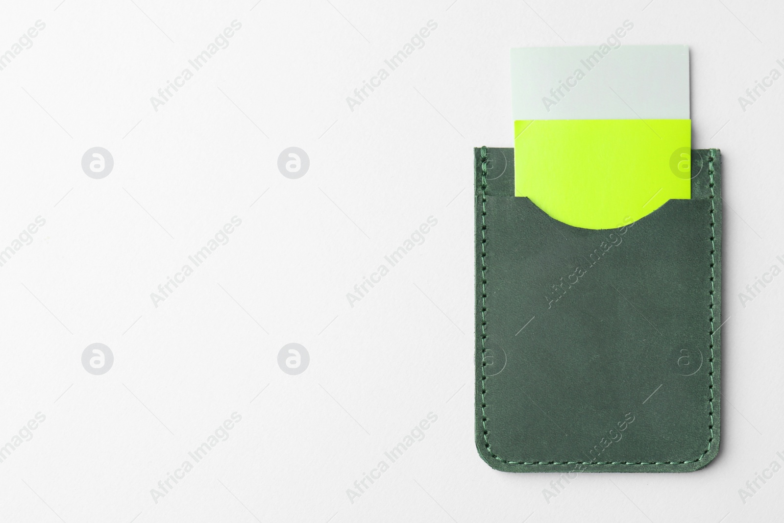 Photo of Leather business card holder with colorful cards on light grey background, top view. Space for text