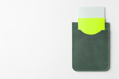 Photo of Leather business card holder with colorful cards on light grey background, top view. Space for text