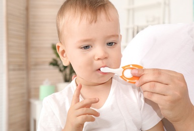 Woman and her son with toothbrush on blurred background