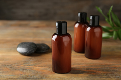 Cosmetic products and spa stones on wooden table